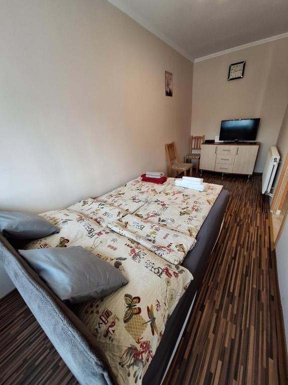 a bedroom with a bed with a blanket on it at Anikó Apartman in Siófok