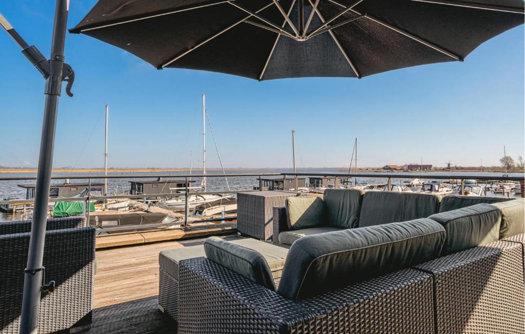 eine Terrasse mit Sofas und einem Sonnenschirm auf einem Boot in der Unterkunft Oostergeest Beneden 2 Slaapk in Uitgeest