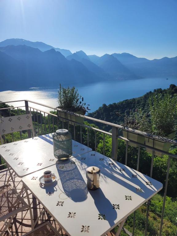 a table on a balcony with a view of the water at La Bella Vista-panoramic lake view, terrace & swimming pool in Fonteno