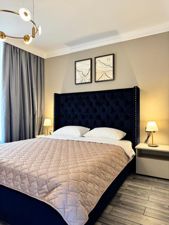 une chambre avec un grand lit avec une tête de lit noire dans l'établissement Апартаменти SeaGems, à Karolino-Buhaz