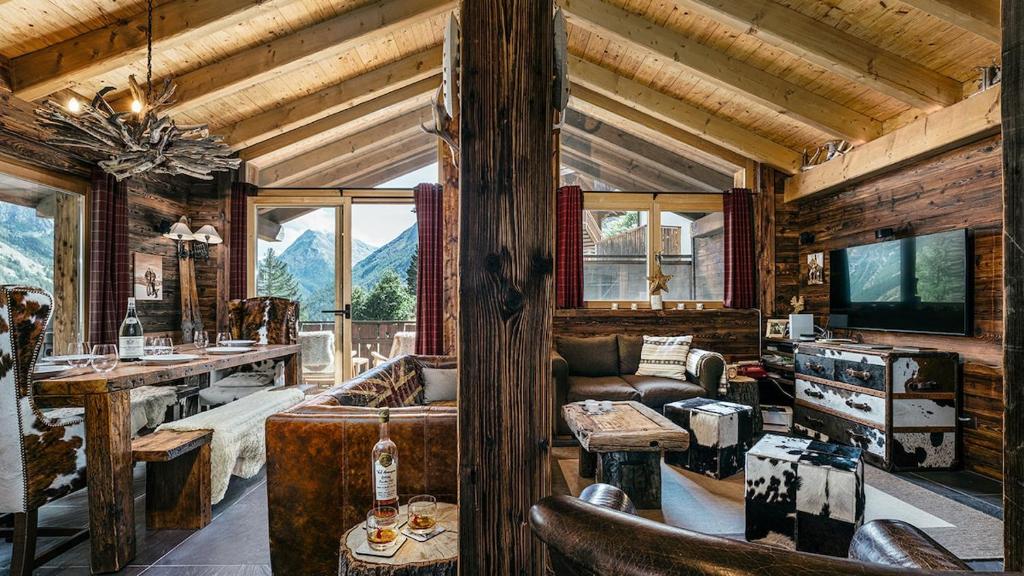 a living room with a couch and a tv in a cabin at CHALET MOUTON a 4-Bedroom Alpine Chic Escape in Saas-Fee in Saas-Fee