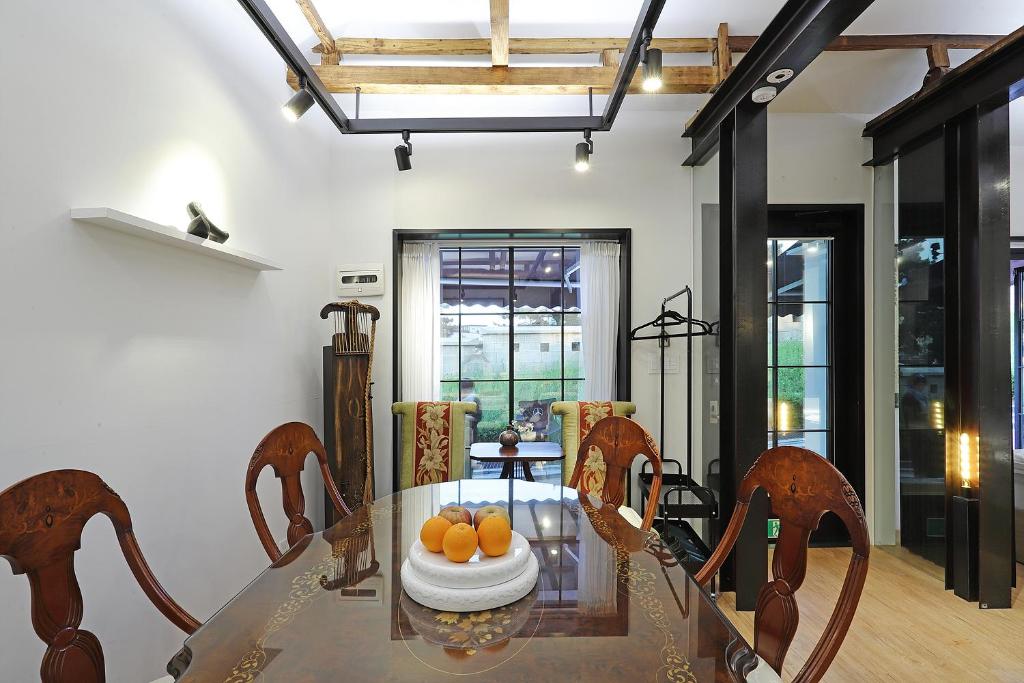 ein Esszimmer mit einem Glastisch und Stühlen in der Unterkunft Jian Hanok in Seoul