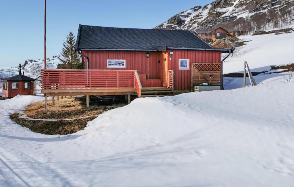 Pet Friendly Home In Snefjord With Sauna في Snøfjord: كوخ أحمر في الثلج بجوار الجبل