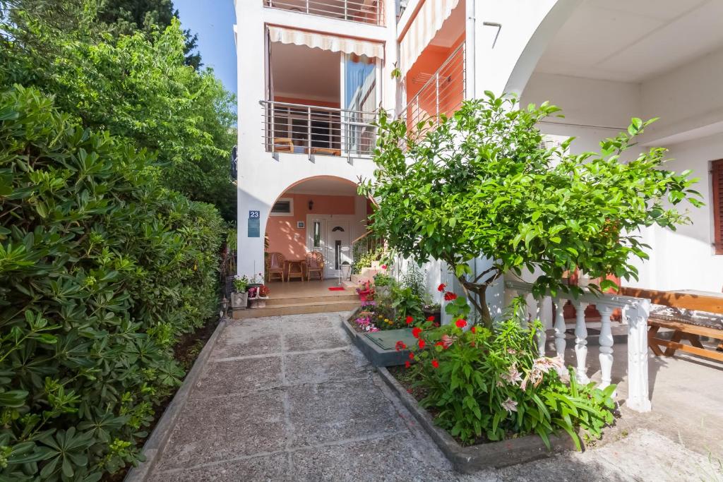 a courtyard of a house with plants and a fence at Apartments Kovačević in Petrovac na Moru