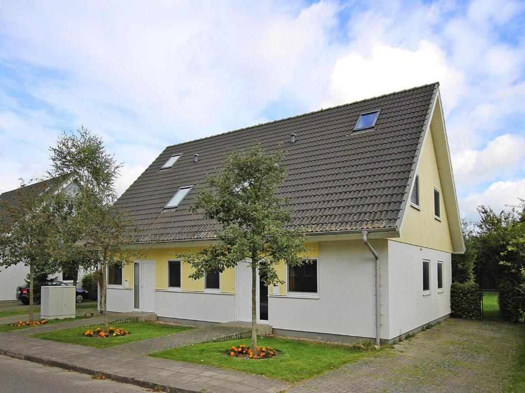 a white and yellow house with a tree in front of it at Ferienanlage im Mueritz-Nationalpark in Mirow in Mirow