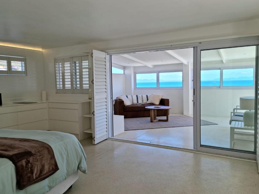 ein Schlafzimmer mit Bett und ein Wohnzimmer in der Unterkunft 'Kaya Moya' - Luxury Suite for 2 with Ocean Views in Gordonʼs Bay
