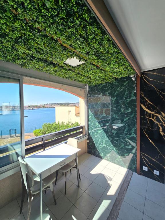 a table and chairs on a balcony with a view of the water at L'Essentiel in Cap d'Agde