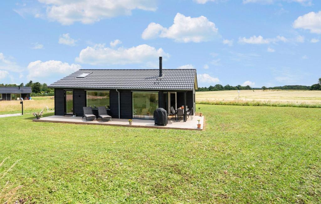 una pequeña casa en una terraza en un campo en 3 Bedroom Stunning Home In Stege, en Stege