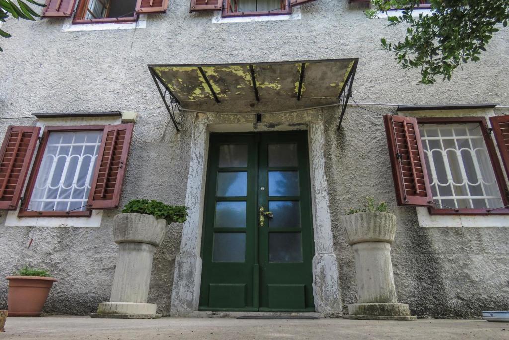 una puerta verde en un edificio con ventanas en apartman kostrena, en Kostrena