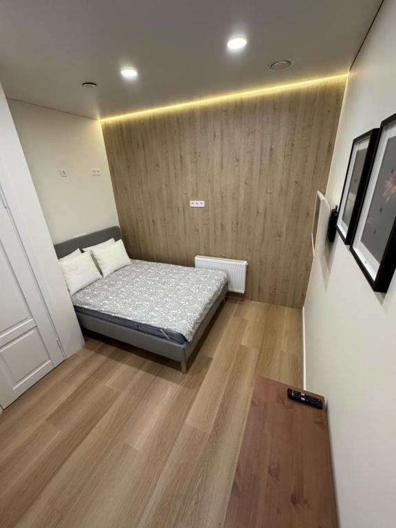 a small bedroom with a bed and a wooden floor at 12 New Airport Apartment in Pakopi