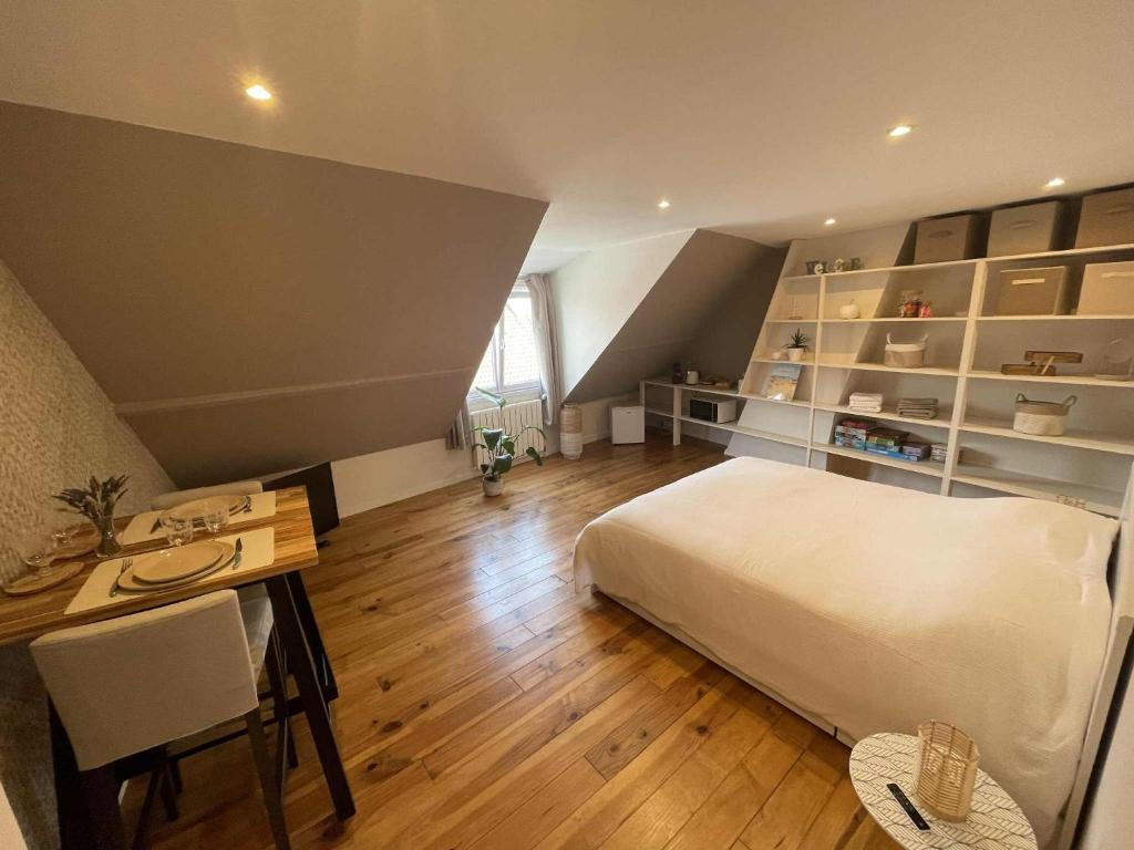 ein Schlafzimmer mit einem Bett, einem Schreibtisch und einem Tisch in der Unterkunft L'écorce marine in Sangatte