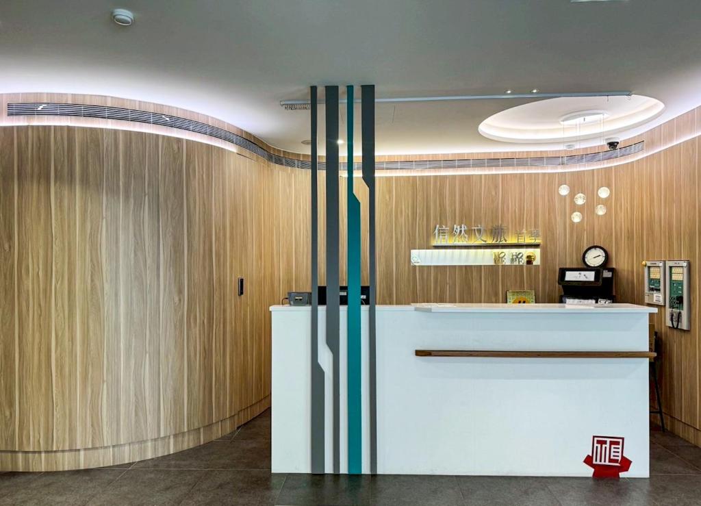 an office lobby with a counter and wooden walls at 信然文旅-New 凝萃海安NCH- Haian Hotel in Tainan