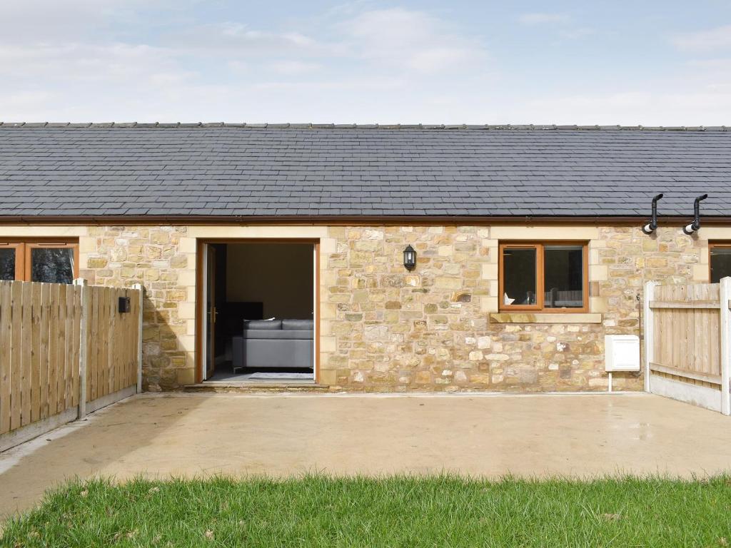 a stone house with a wooden fence in front of it at Two Dorchester Drive - Uk32036 in Inglewhite