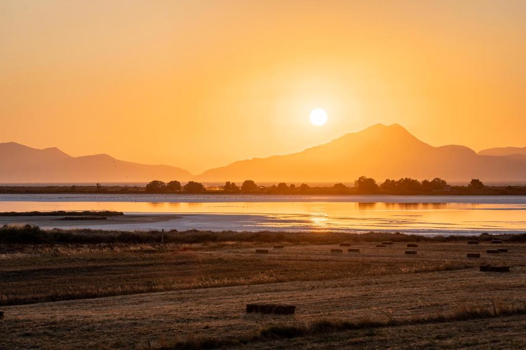 a sunset over a river with mountains in the background at Oasis Tigaki in Tigaki