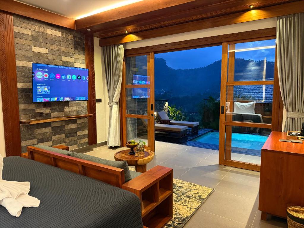a bedroom with a television and a living room at Kankhara Villas Sidemen in Sidemen