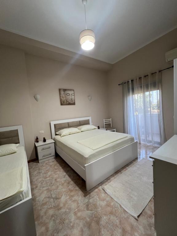 a bedroom with a large white bed and a window at Dyrrah G In the heart of Durres in Durrës