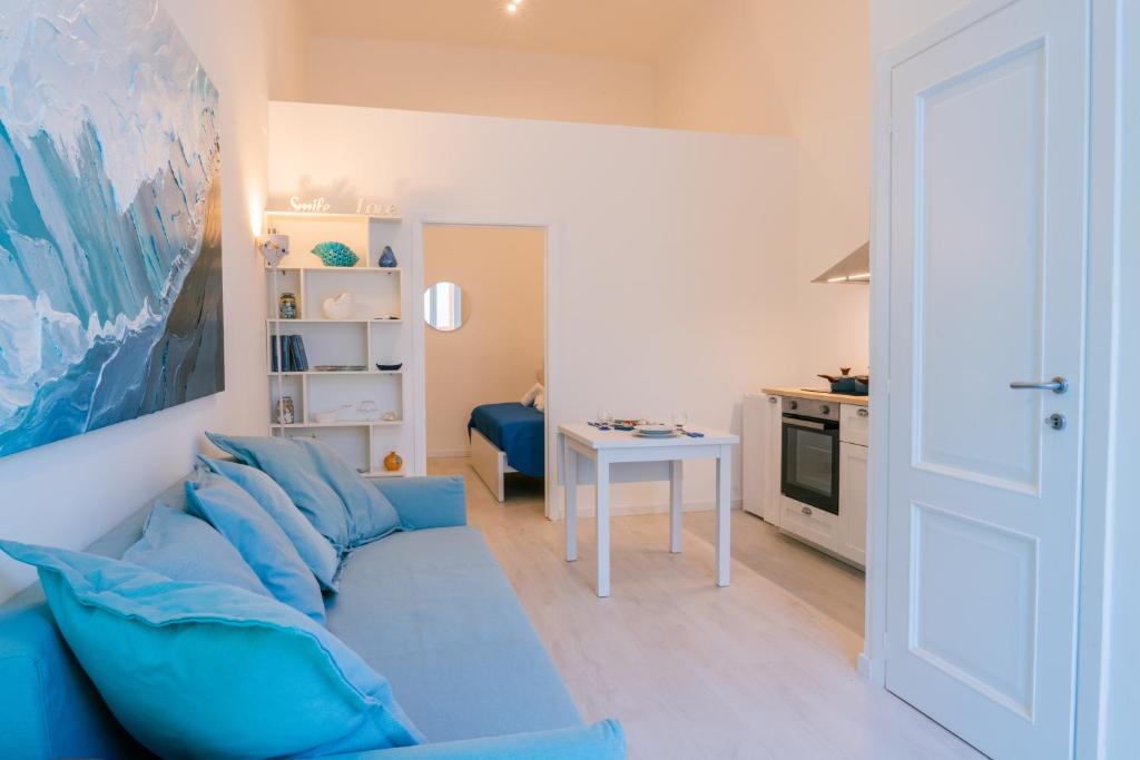 a living room with a blue couch and a table at Rosalù - Sea View in Polignano a Mare