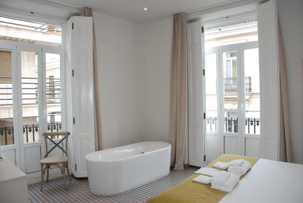 een witte badkamer met een bad en een wastafel bij Hotel San Lorenzo Boutique in Valencia