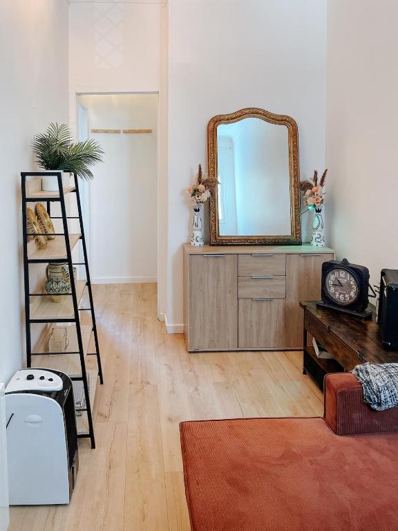 a living room with a mirror and a wooden dresser at Quiet and bright apartment with separate bedroom in Nice