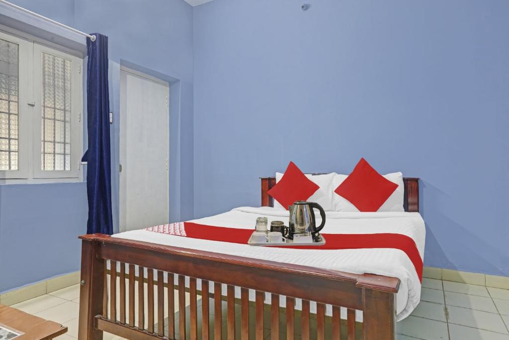 a bedroom with a large bed with red pillows at Hotel O Stayz in Auroville