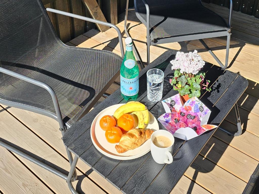 a table with a plate of food and a bottle of wine at MOMA apartments - enjoy moments in Liepāja