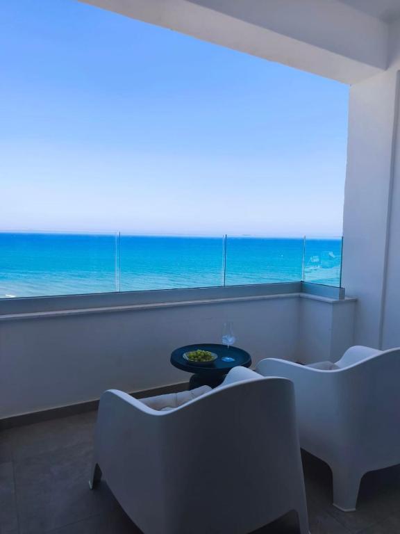 a room with chairs and a view of the ocean at Joyscape beachfront residence in Larnaca