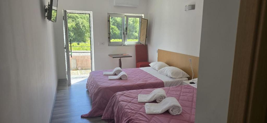 two beds with towels on them in a room at Residencial Hospedaria Vale do Rodo in Peso da Régua