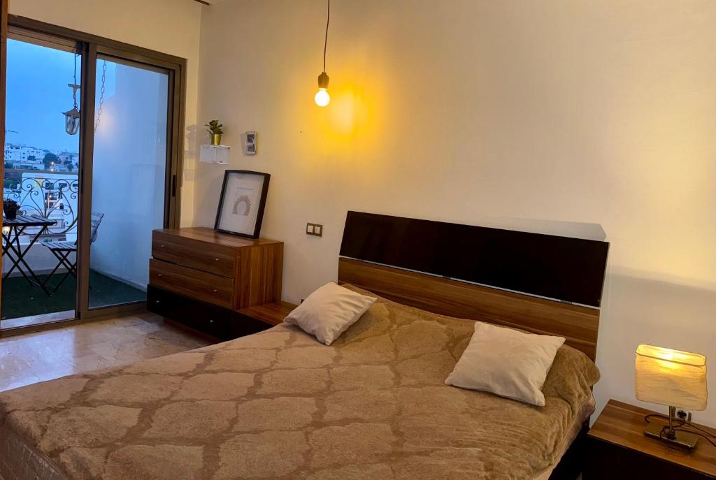 a bedroom with a bed and a dresser and a window at Appartement familial in Casablanca