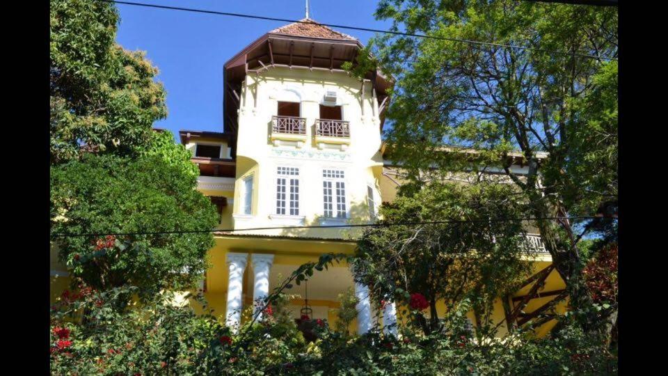 Edificio amarillo y blanco con balcón en Villa Alexandrino, en Río de Janeiro