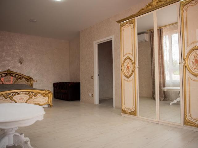 a bedroom with a bed and a large mirror at AMSTERDAM hotel&swimming pool in Suprunovka