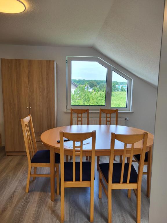 ein Esstisch mit Stühlen und ein Fenster in der Unterkunft Fredi Apartment, moderne ruhige Wohnung, nur 4 km von der A2 in Leopoldshöhe