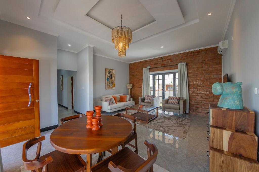 a living room with a wooden table and chairs at Paris Royal Estate in Lusaka
