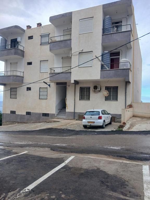 a white car parked in front of a building at Résidence Aslouni Aach el vaz saket Béjaïa Algérie in Bejaïa
