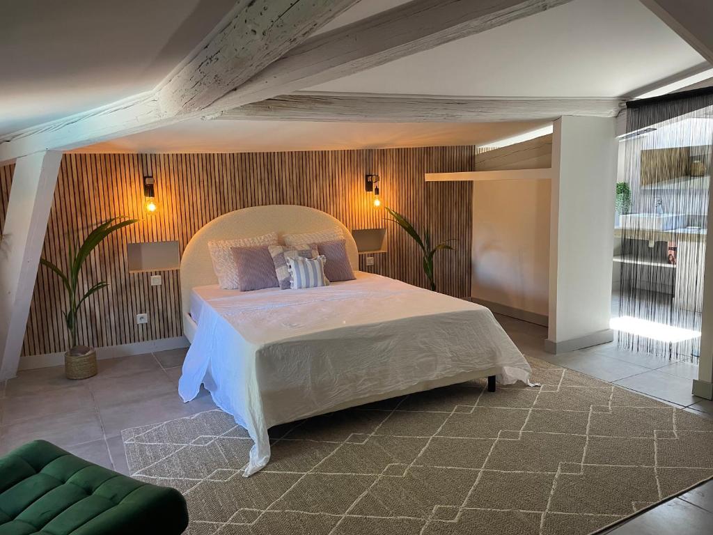 - une chambre avec un grand lit et un canapé vert dans l'établissement La Tuilerie du Bazalac, à La Celle-sous-Gouzon