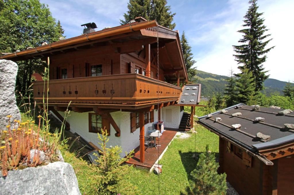 a large wooden house with a balcony on a hill at Ferienwohnung Königsleiten 251 - Top EG in Königsleiten