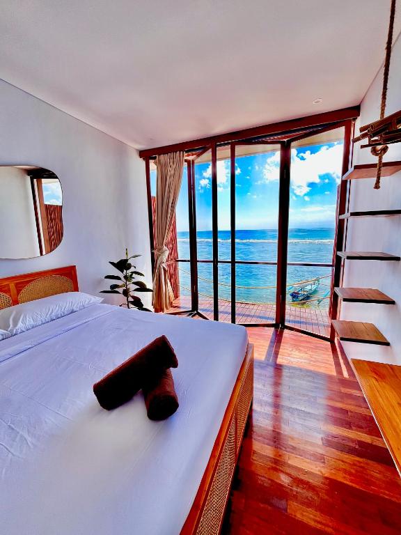 a bedroom with a bed with a view of the ocean at The Ohm At Thomas Beach in Uluwatu
