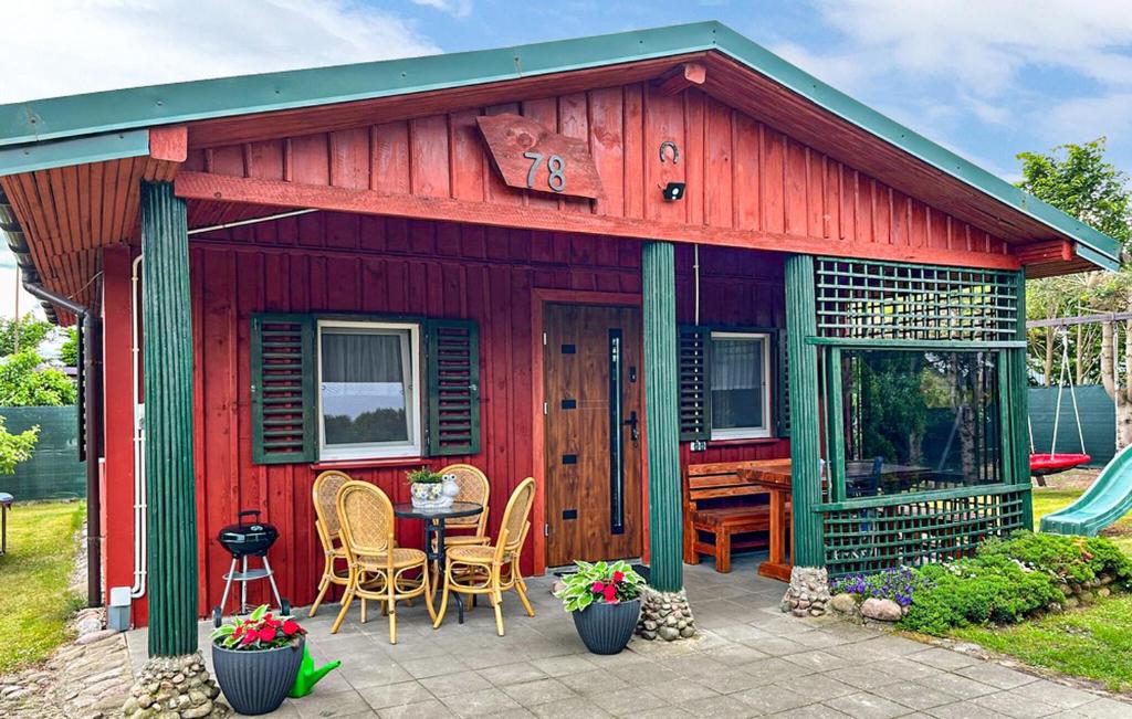 a red house with a table and chairs in front of it at 1 Bedroom Gorgeous Home In Mscice in Mścice