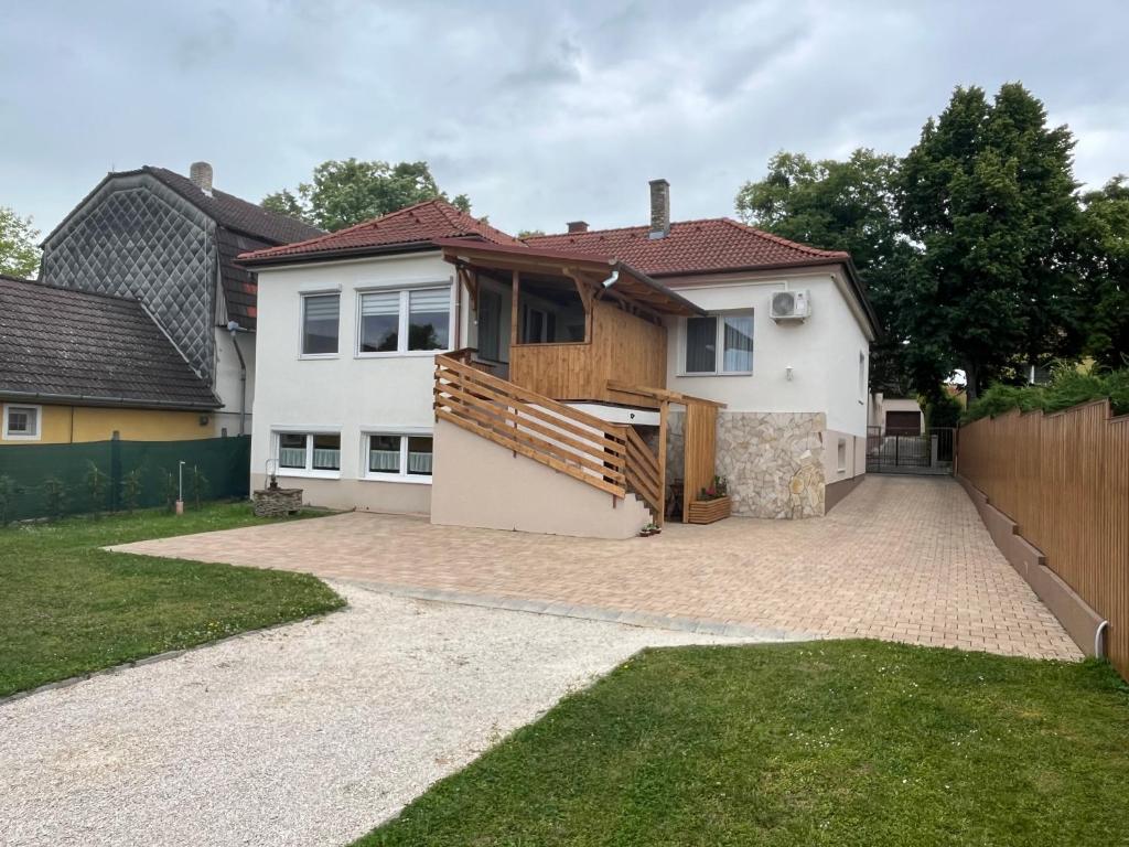 a white house with a fence and a driveway at Gold Apartmann Hévíz in Hévíz