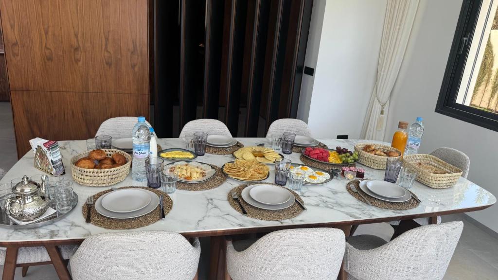 a table with plates and baskets of food on it at Villa Talya in Marrakech