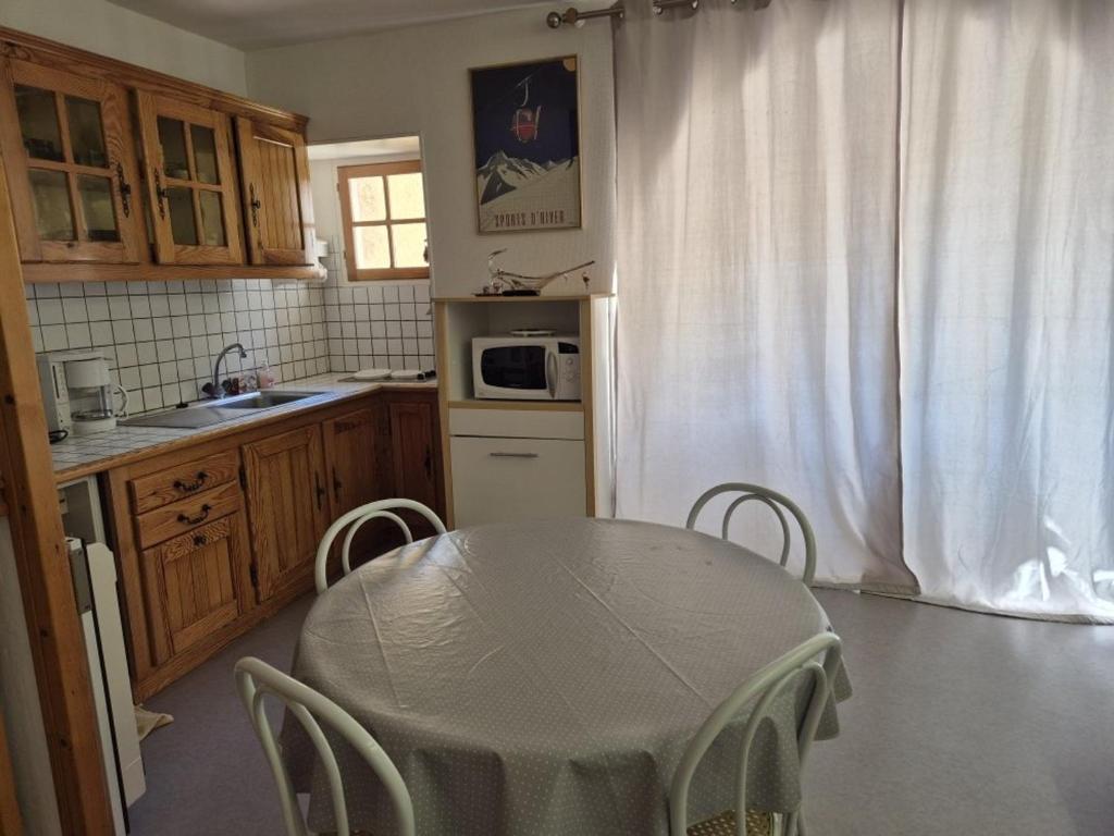 une cuisine avec une table et des chaises dans une cuisine dans l'établissement Bel Appartement en Centre, 1 Ch, Près Télécabines - FR-1-234-317, à Cauterets