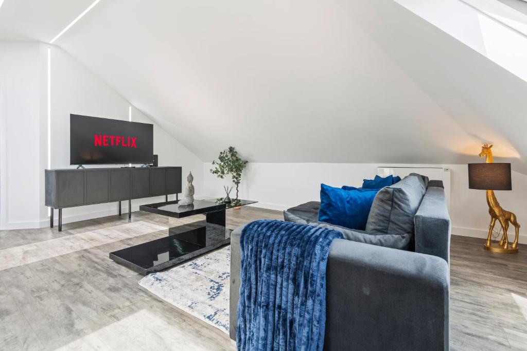 a living room with a couch and a tv at Stunning Penthouse-Style 2-Bed Uxbridge in Uxbridge