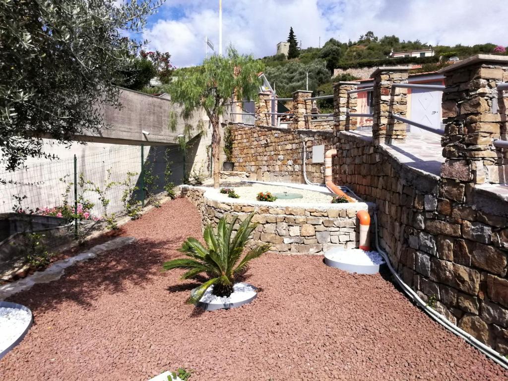 a backyard with a stone wall and a fountain at Villetta da Amare in Imperia