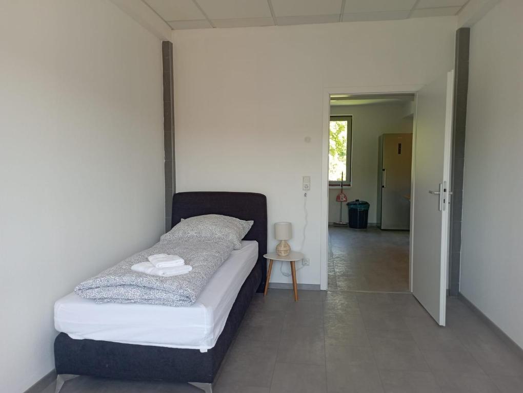 a bedroom with a bed and a hallway at Monteurwohnung Monti 2 in Saarbrücken