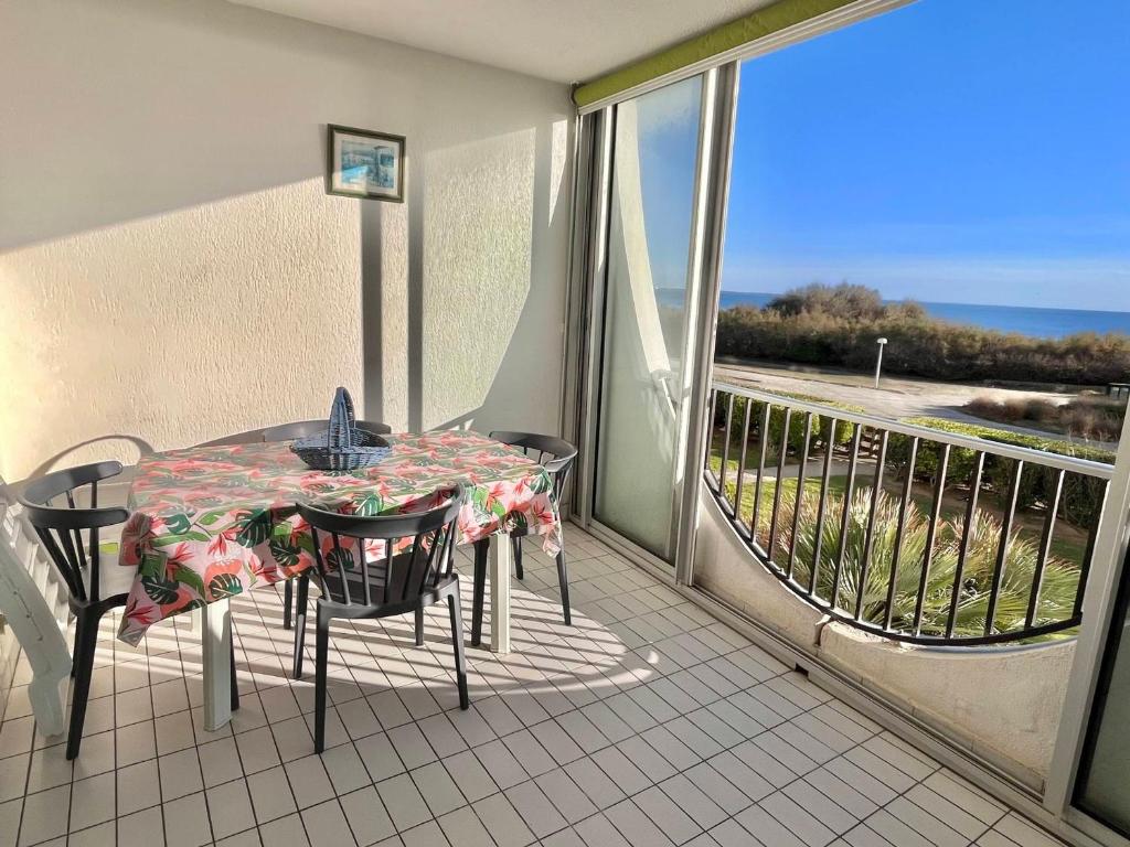 une table et des chaises sur un balcon avec vue sur l'océan dans l'établissement Bel Appartement T2 - 5 pers, Ligne 1, Plage, Parking - FR-1-716-23, à La Grande Motte