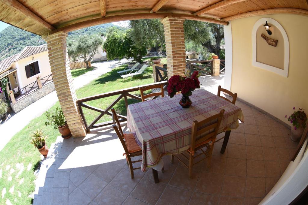 eine Veranda mit einem Tisch und Stühlen auf einer Terrasse in der Unterkunft Yannis' Village in Kerion