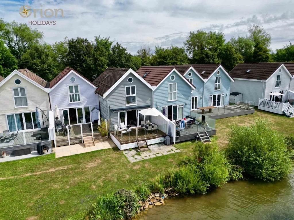 a row of houses next to a river at Spring Lake 19, The Lake House in South Cerney