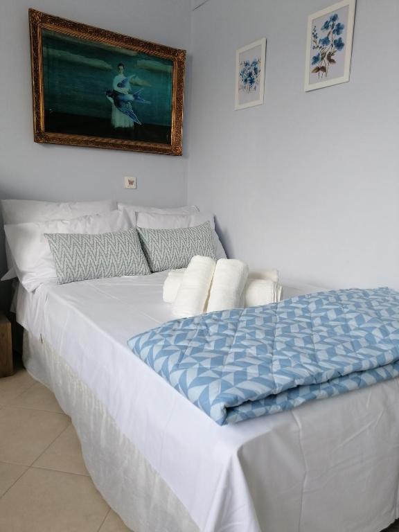 a bed in a bedroom with a picture on the wall at Bluefullstop-Μπλε Τελεία in Artemida