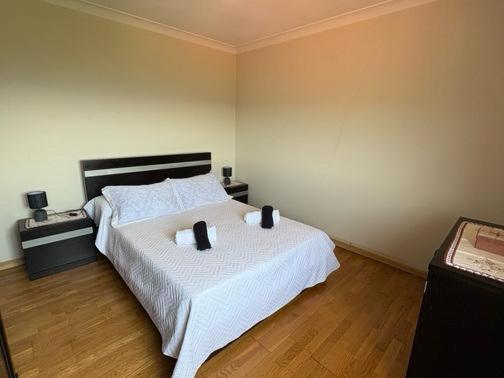 a bedroom with a large white bed with two pillows at La Casa de Marta in Ribeira de Pena