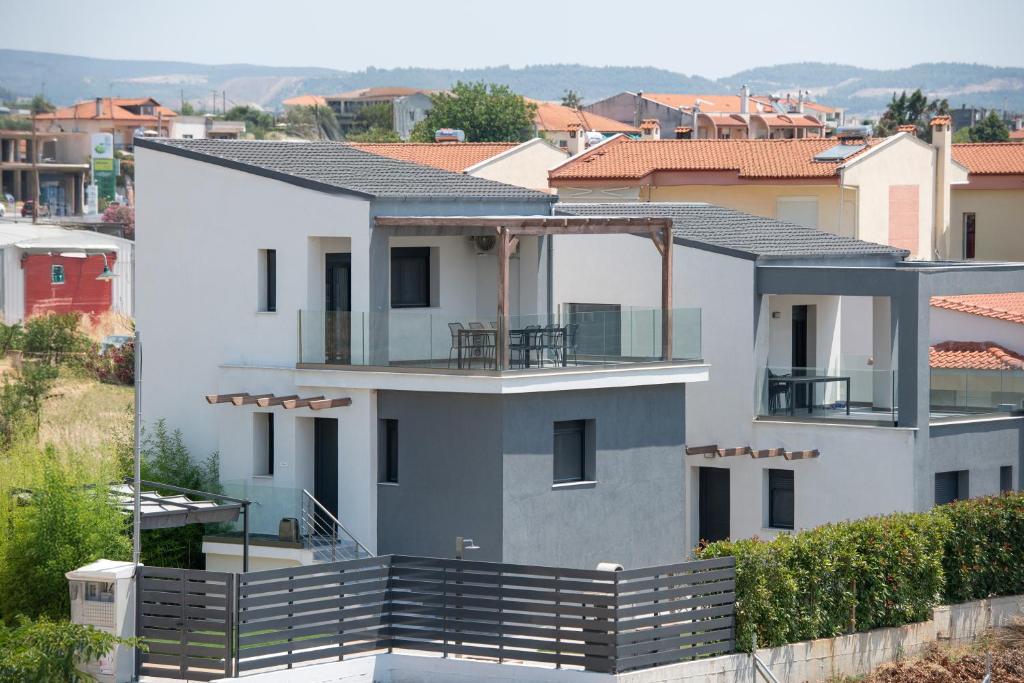 Una casa blanca con un balcón encima. en Asteria Mare by Aetherion Studios & Suites, en Kalivia Poligirou