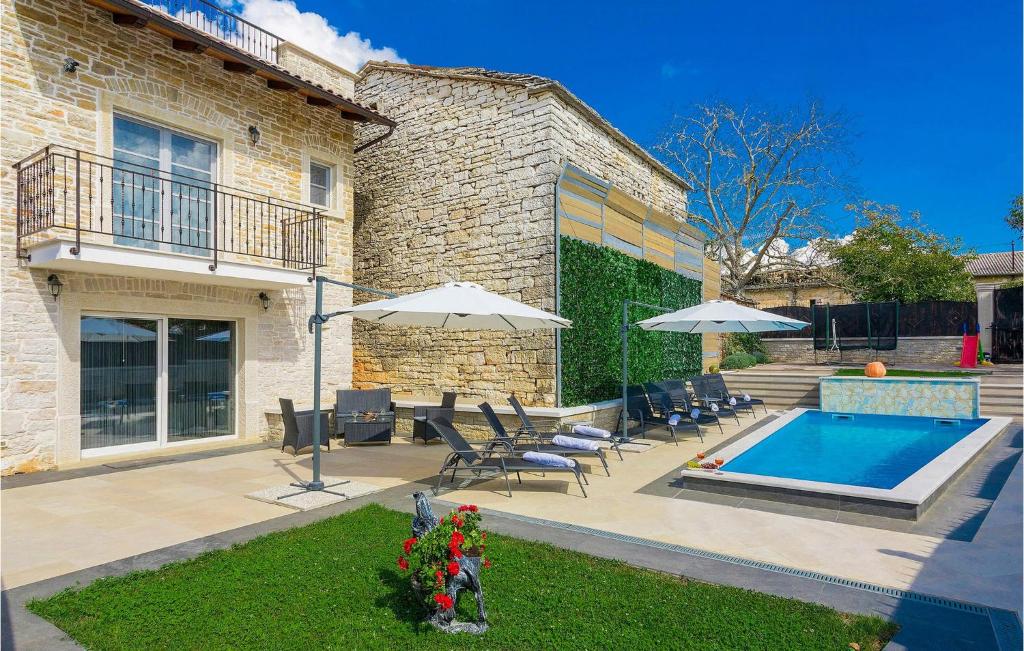 una casa con piscina, sillas y sombrillas en Villa Patrick, en Pazin